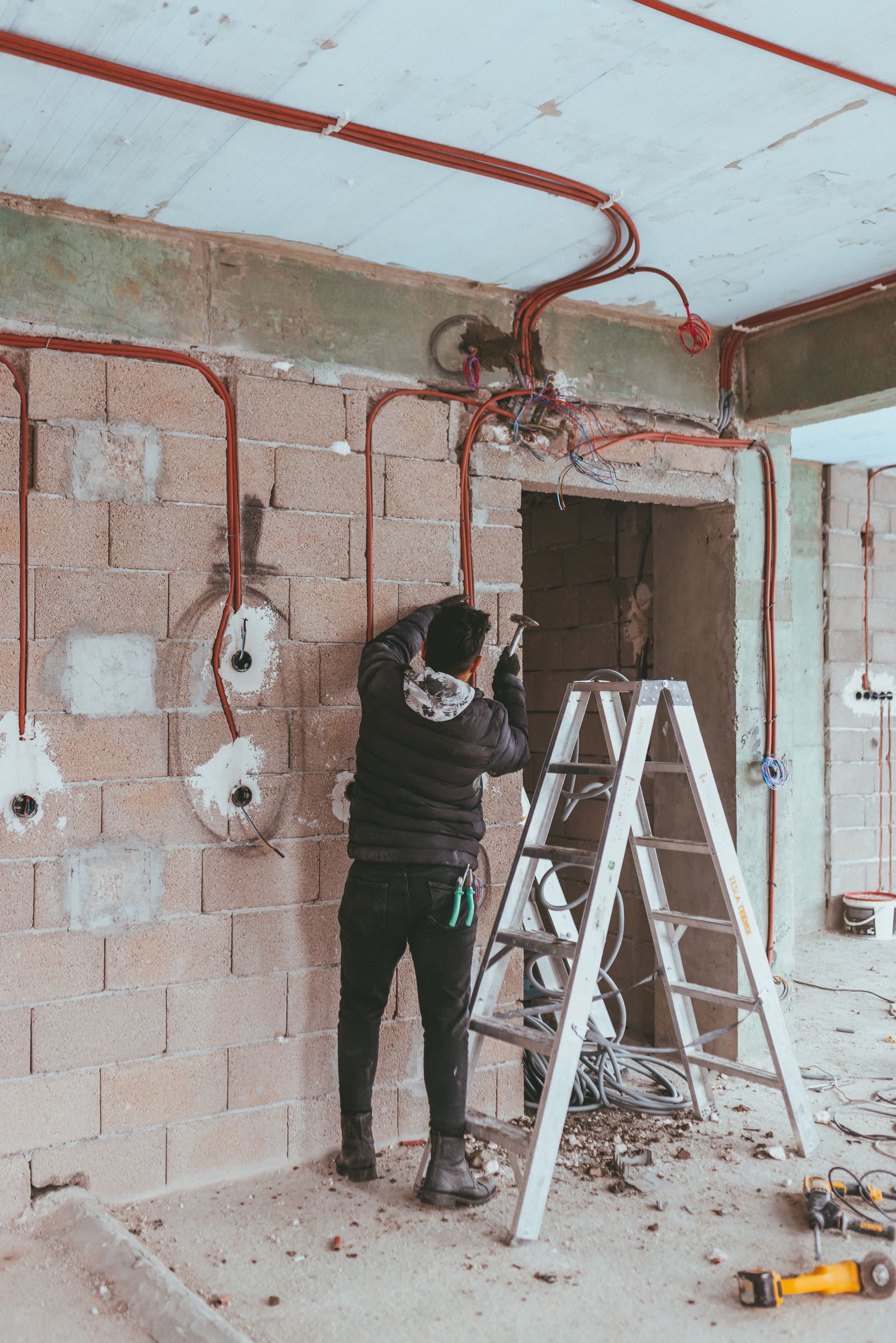 Rohinstallation: Elektriker verlegt Leitungen und setzt Dosen im Rohbau